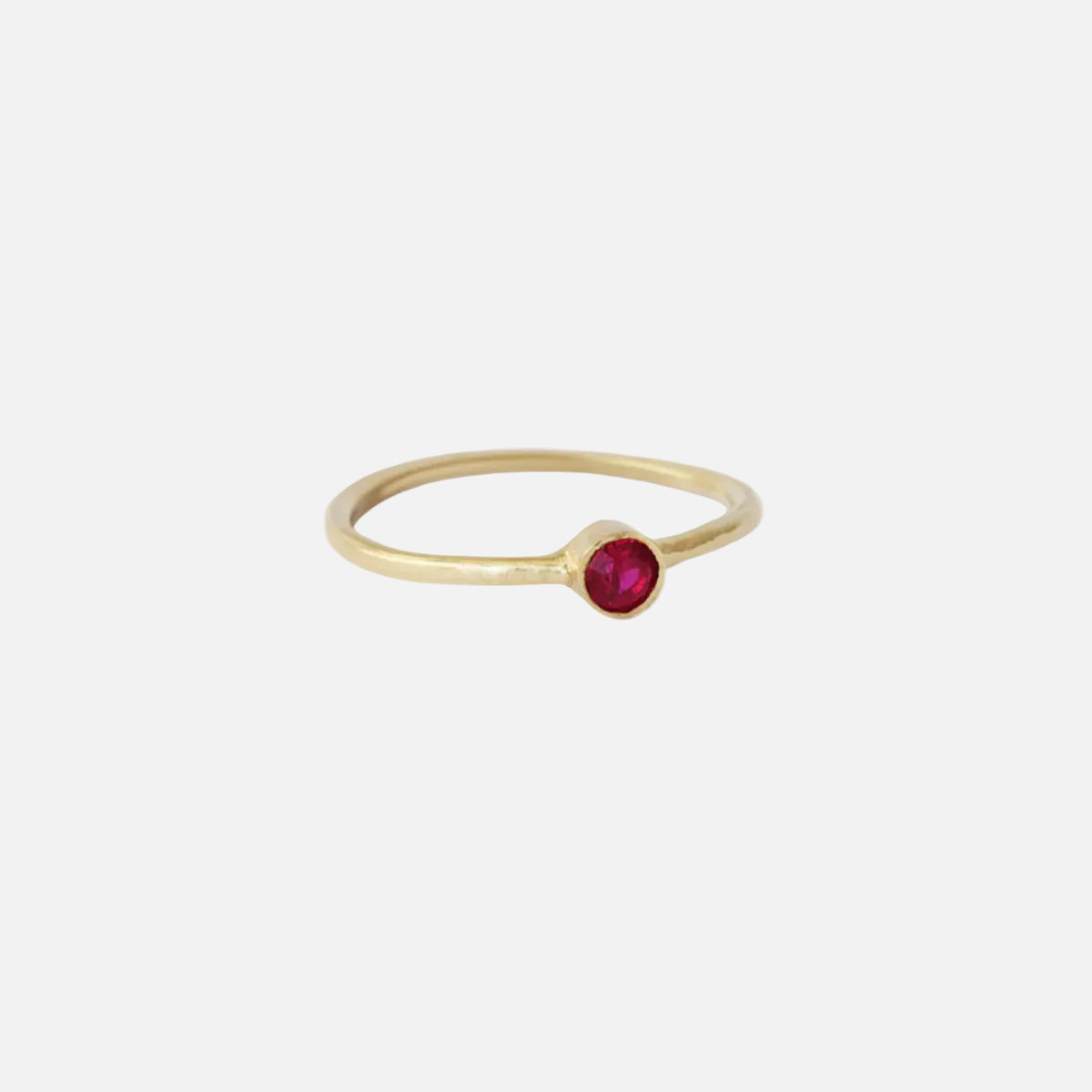 Ruby Dainty Ring, a stunning piece of jewelry with an elegant design that exudes sophistication. The delicate and dainty nature of this ring adds a touch sparkling to any outfit. Featuring a beautiful ruby gemstone, this ring is perfect for those who appreciate timeless beauty.Details 3.05mm Red Ruby 1.4mm Round Band 14k Yellow Gold Hammered texture