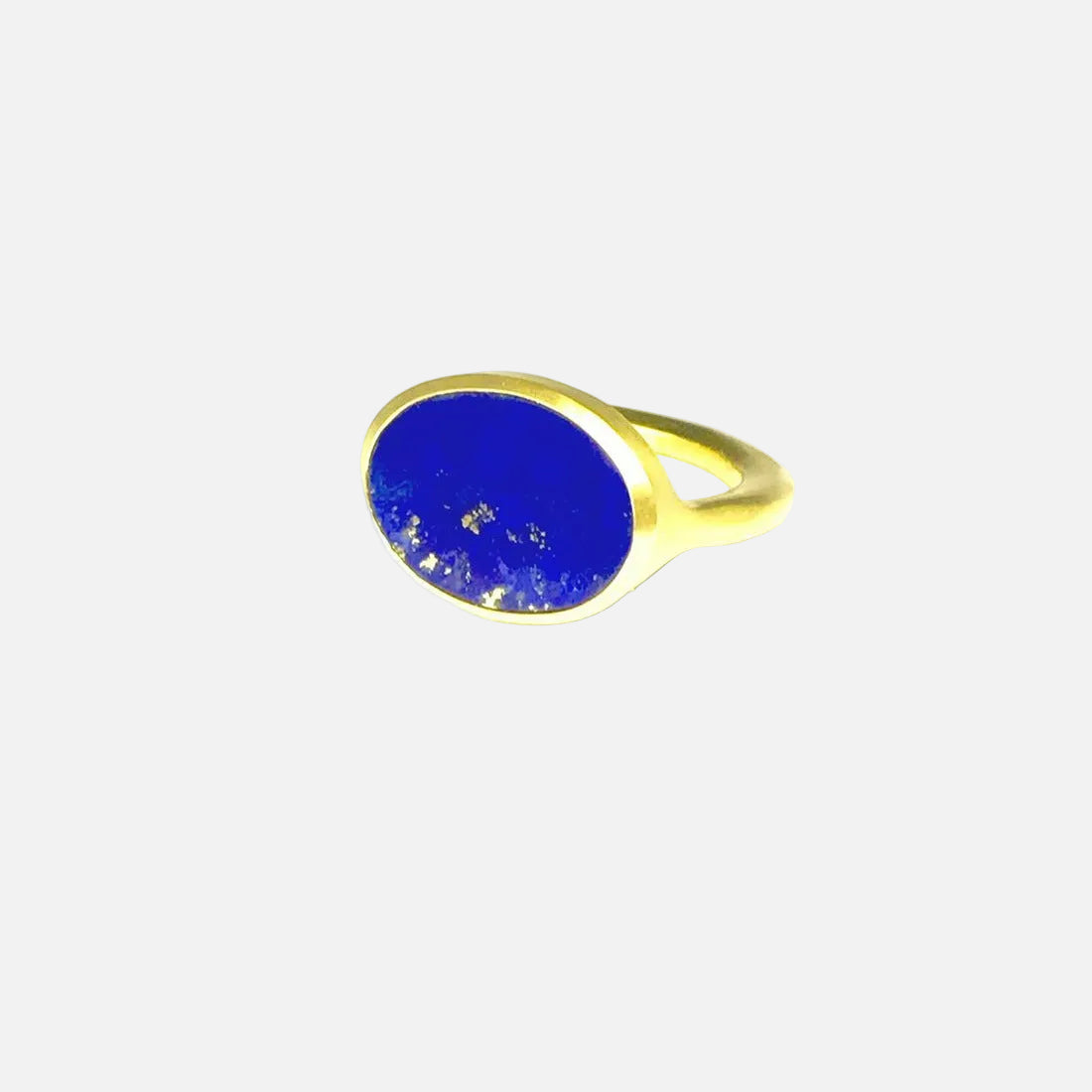 A gold ring featuring a large blue lapis stone, with a visible gold band and a slightly altered surface.