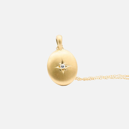 A gold locket pendant with a small diamond in the center, attached to an 18-inch gold chain.