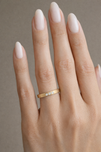 Hand wearing 14k gold memorial ring with three diamonds cremation ashes jewelry by Tricia Kirkland