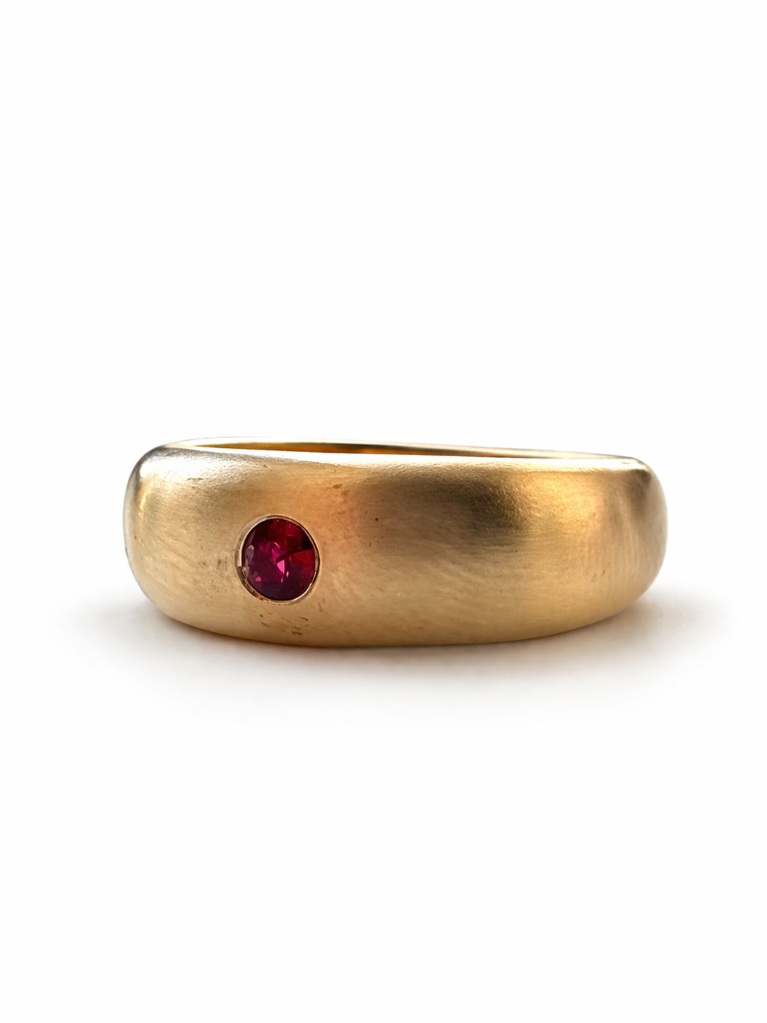 Gold dome  ring with a ruby gemstone on a white background