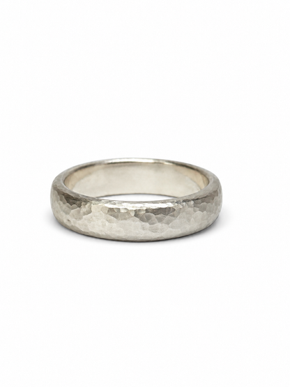 A hammered silver band ring, photographed from a front-facing perspective on a clean white background.